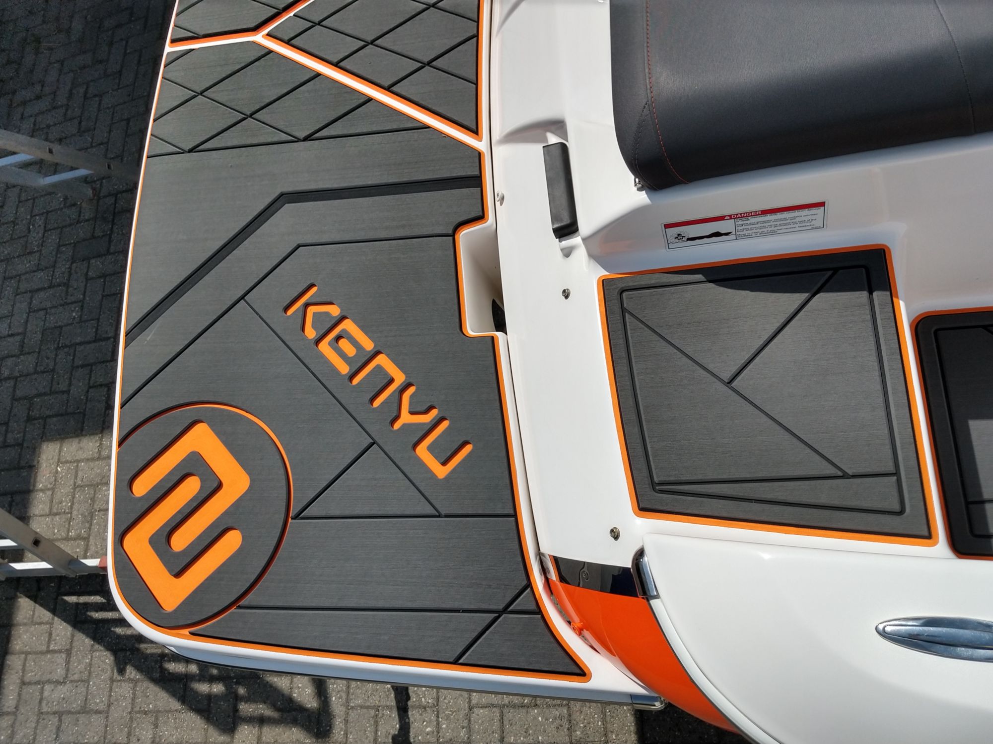 KENYU Signature EVA-Bootsboden, dreilagig mit orangem KENYU-Logo auf der Badeplattform